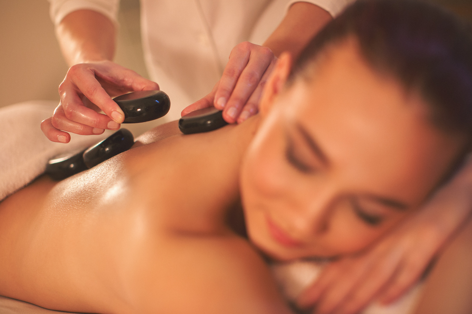 Massage therapyst using lava stones for massage